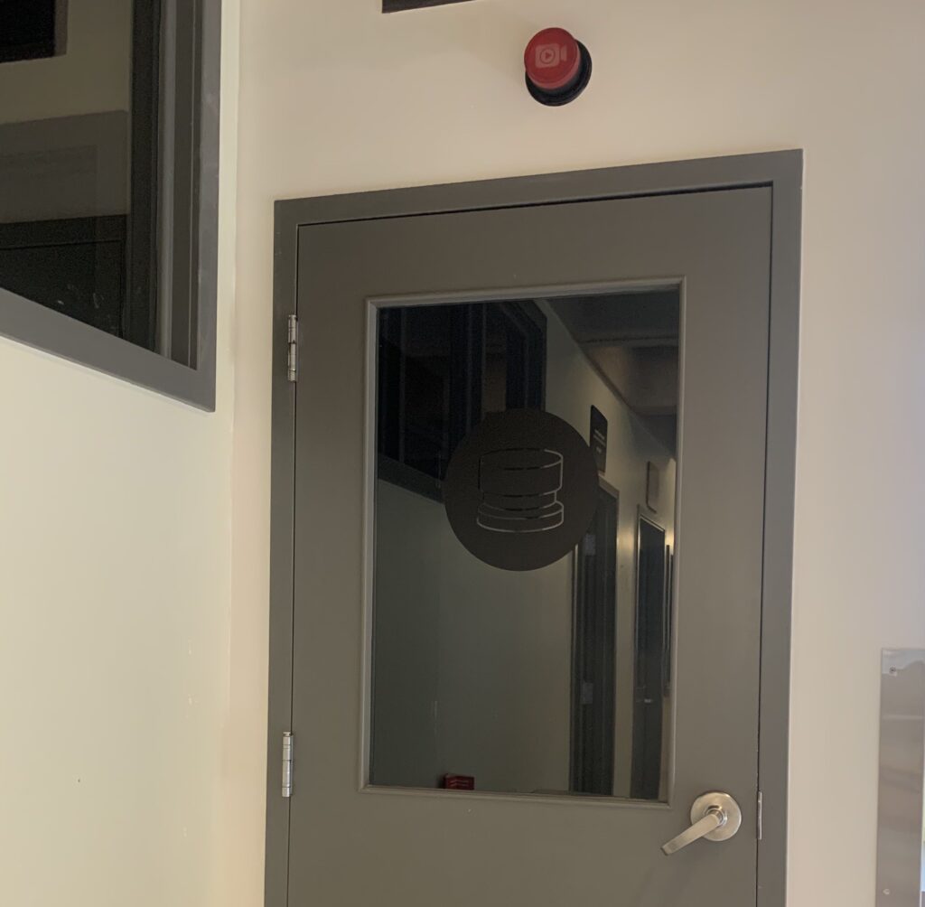 Gray door with red light over it 